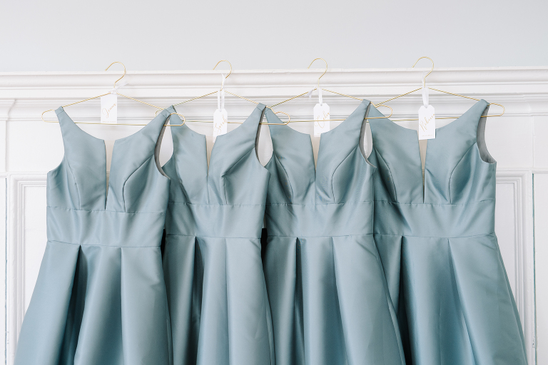 blue bridesmaid gowns, hanging from a fireplace at a black tie wedding in Charleston, SC.  Gadsden House wedding